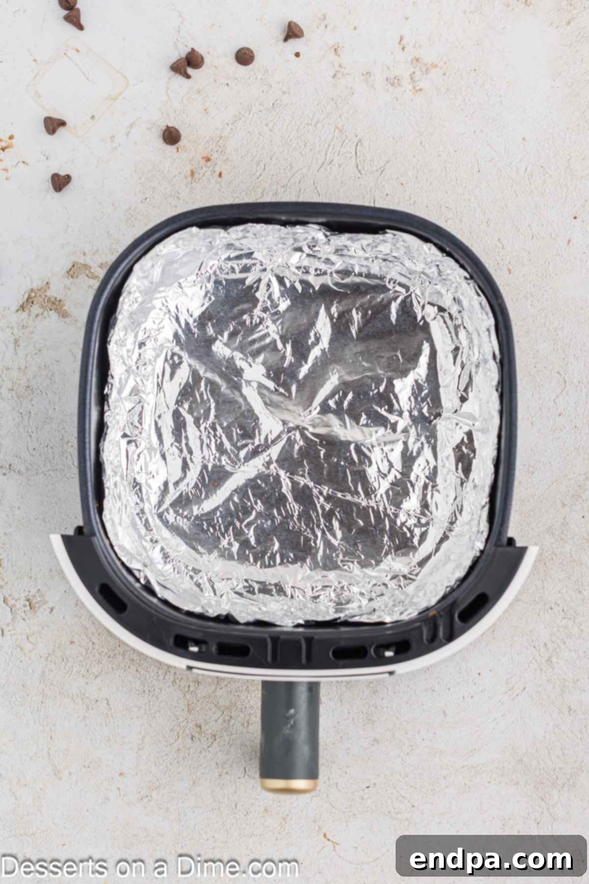 Warm & Gooey Air Fryer Pizookie 4 Air fryer basket lined with aluminum foil, prepared to hold the cookie dough.