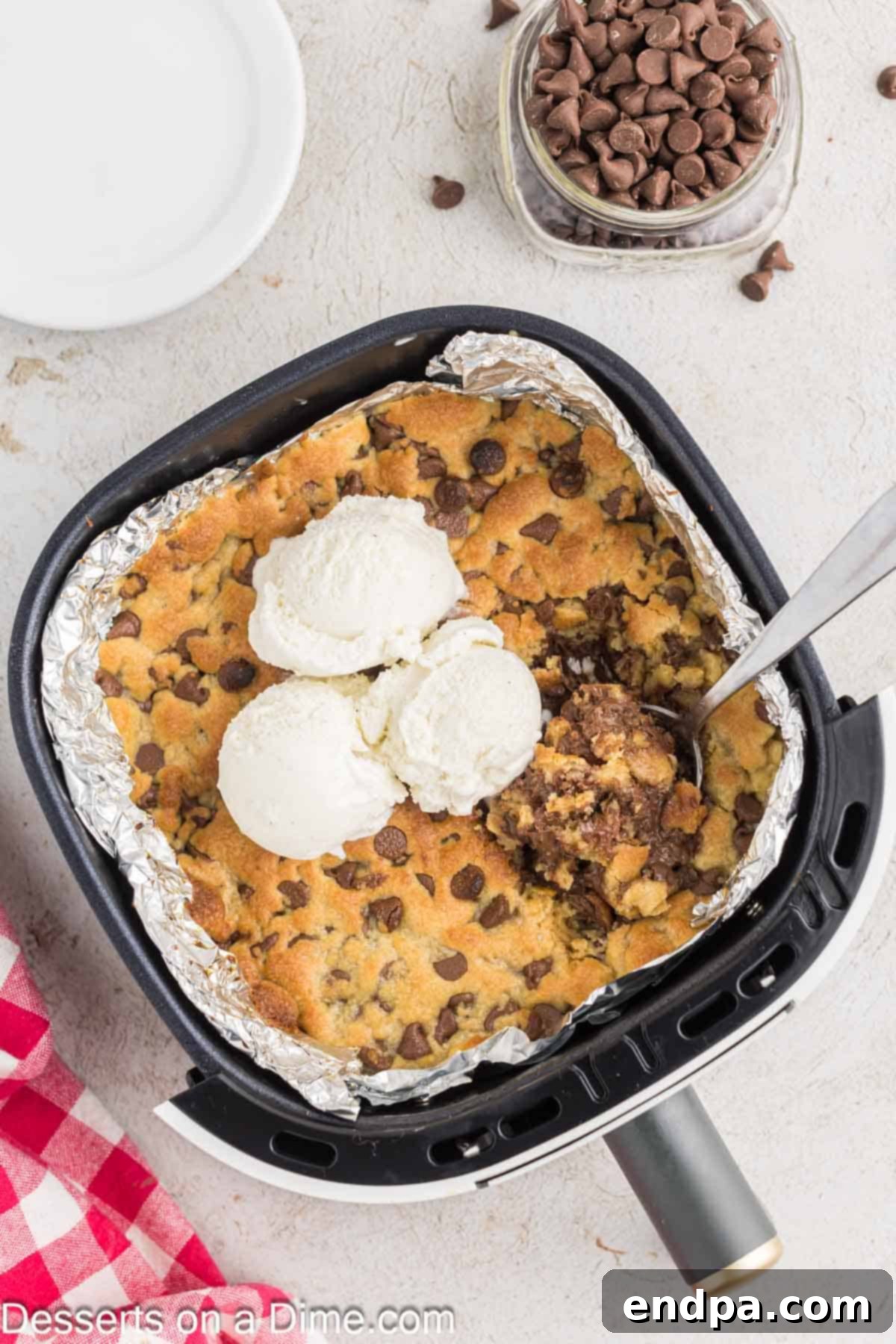 Warm & Gooey Air Fryer Pizookie 10 Close-up of a warm Air Fryer Pizookie, topped with a melting scoop of vanilla ice cream and chocolate sauce, ready to be devoured.