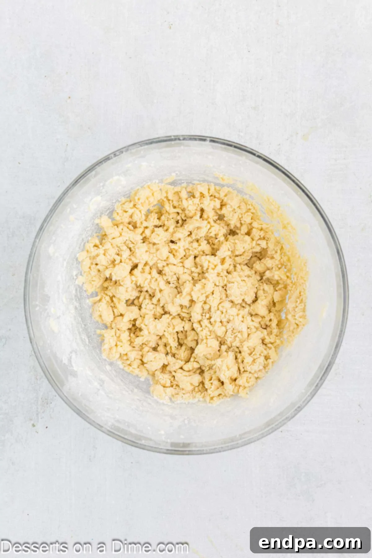 Crimson Cherry Thumbprint Cookies 5 Dry flour mixture being gradually incorporated into the wet butter and sugar mixture in a bowl, forming cookie dough.