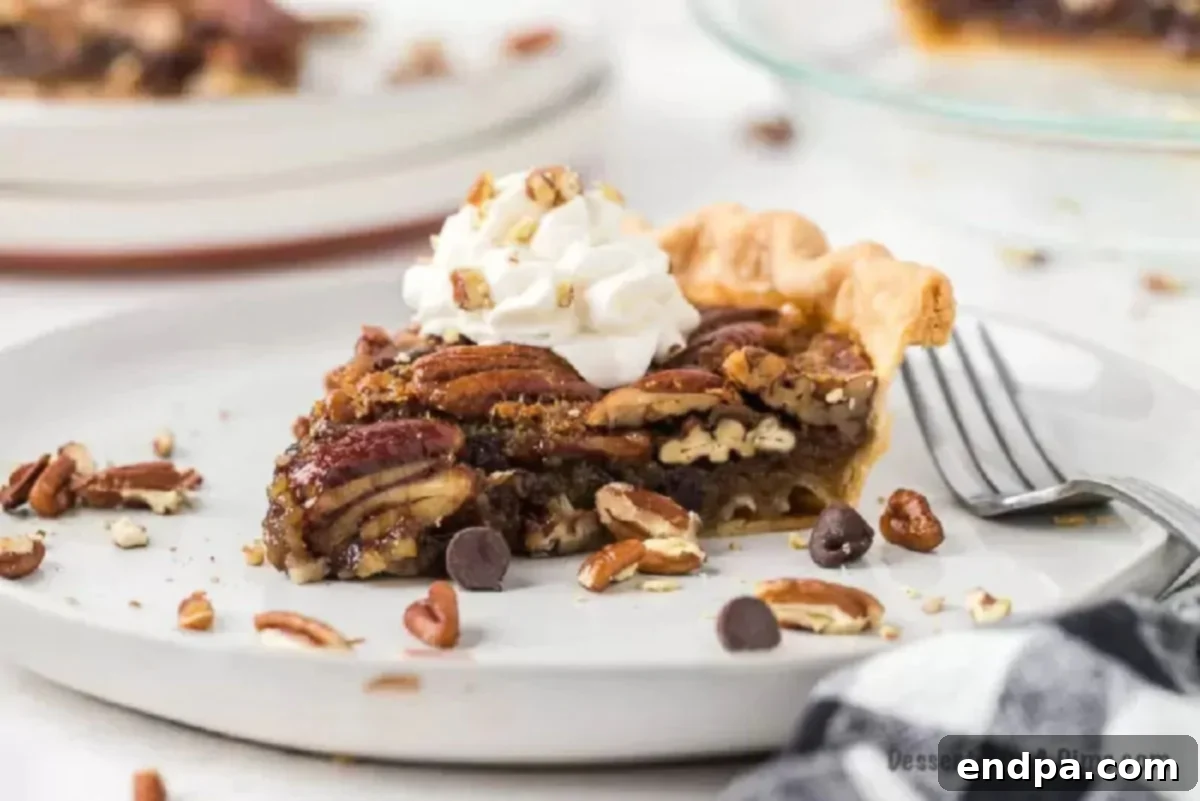 Gooey Chocolate Pecan Perfection 2 Slice of chocolate pecan pie on a plate with whipped cream, ready to be enjoyed.