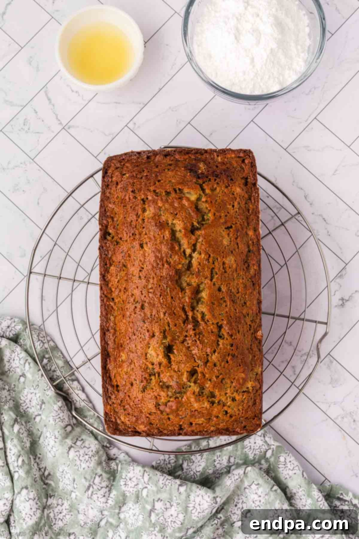 The freshly baked zucchini pineapple bread cooling on a wire rack after being removed from the pan.
