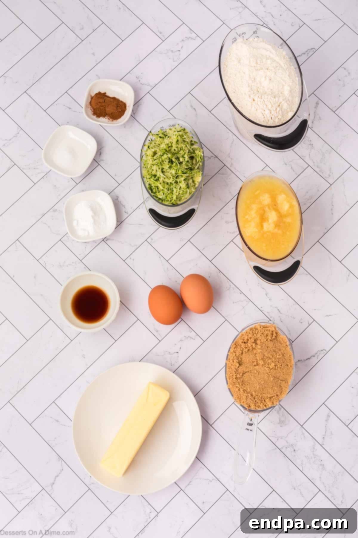 Ingredients laid out for zucchini bread including brown sugar, butter, eggs, vanilla, zucchini, crushed pineapple, flour, baking soda, and cinnamon.