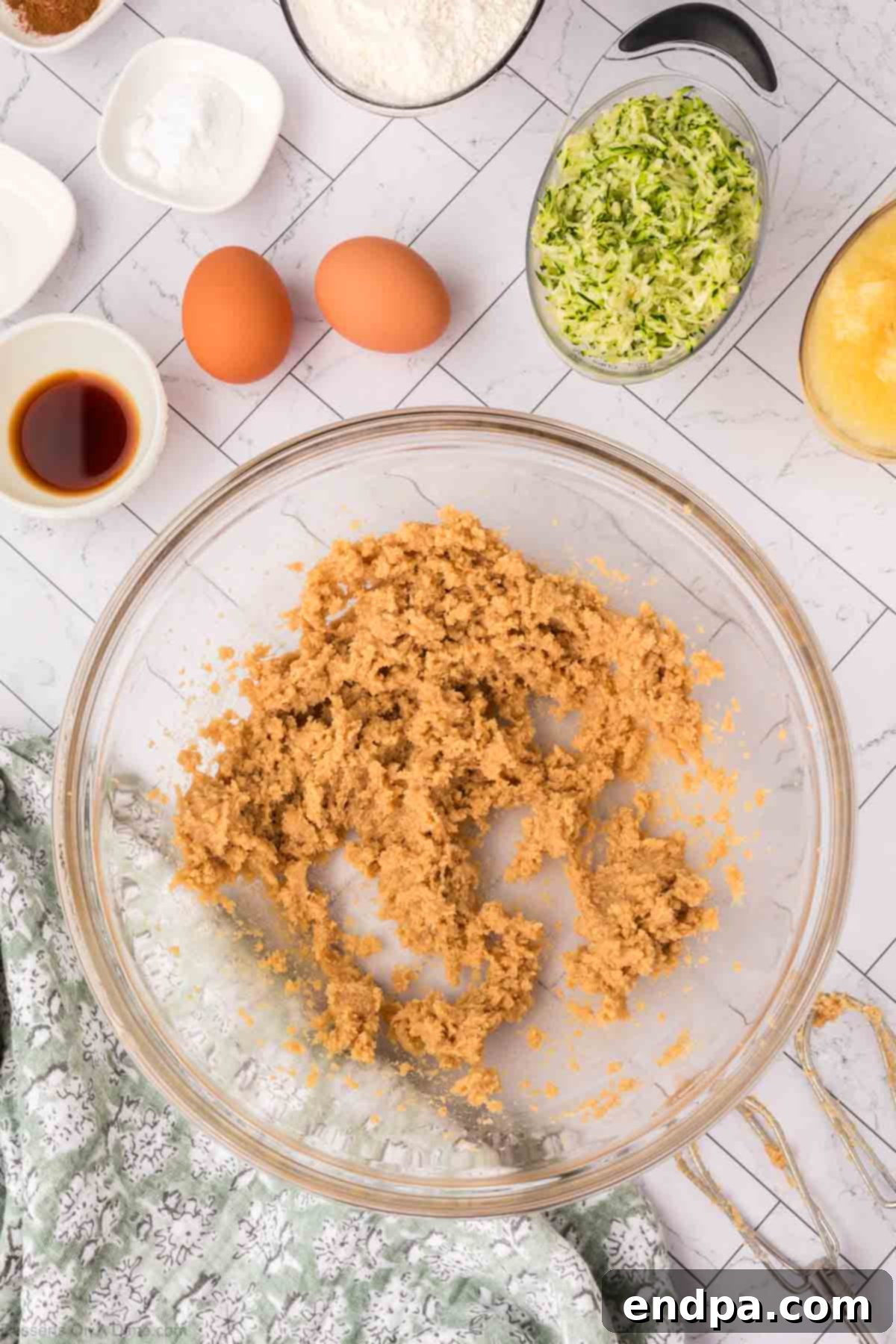 Softened butter and brown sugar being creamed together in a mixing bowl until light and fluffy.