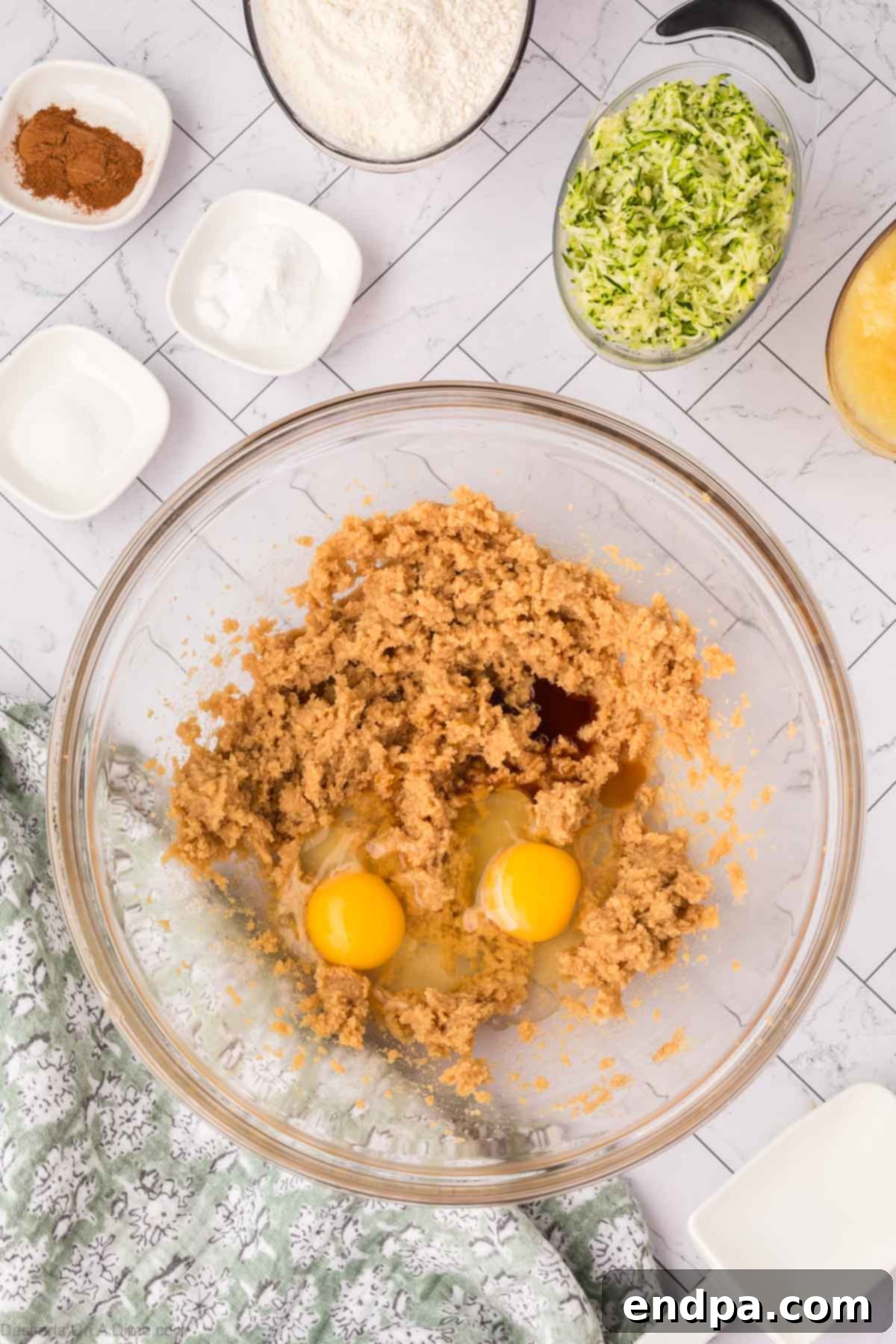 Eggs and vanilla extract being mixed into the creamed butter and sugar mixture.