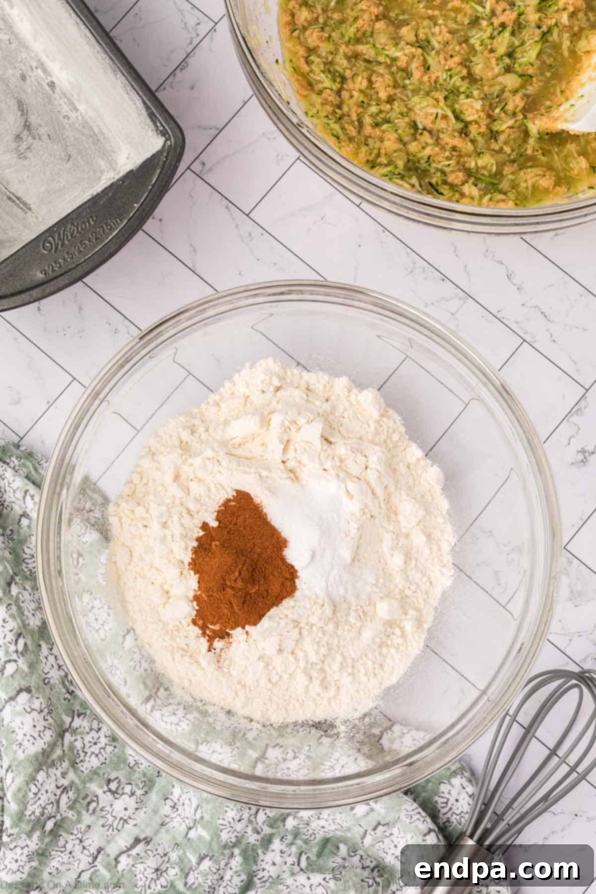 A separate mixing bowl containing the dry ingredients: flour, baking soda, cinnamon, and salt.