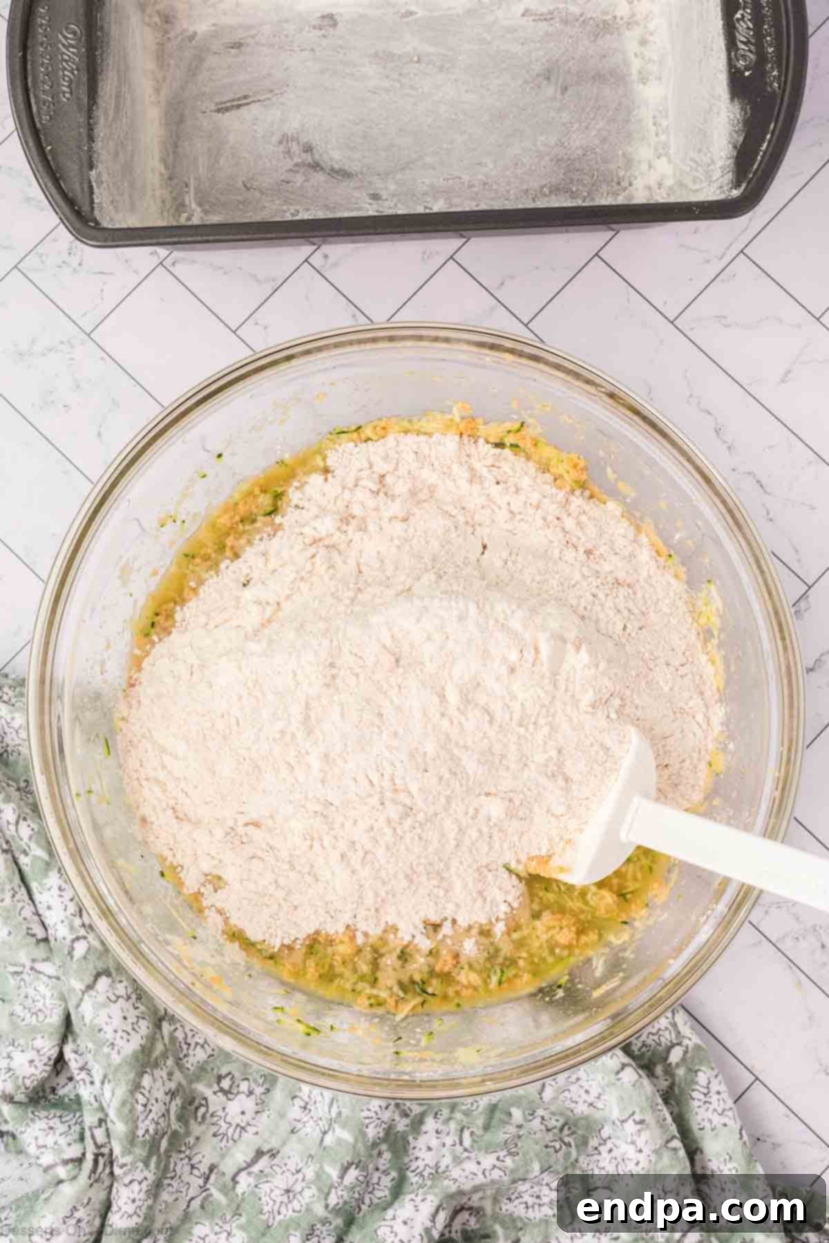 The wet and dry ingredients combined together in a bowl, forming a thick, slightly wet batter.