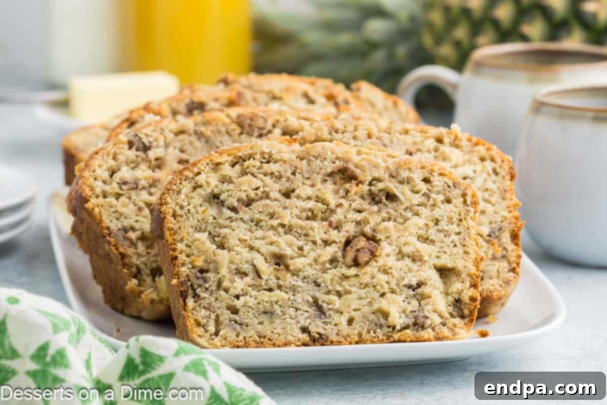 Tropical Banana Pineapple Loaf 2 Banana Pineapple Bread sliced on a platter, showcasing its moist texture and golden crust.