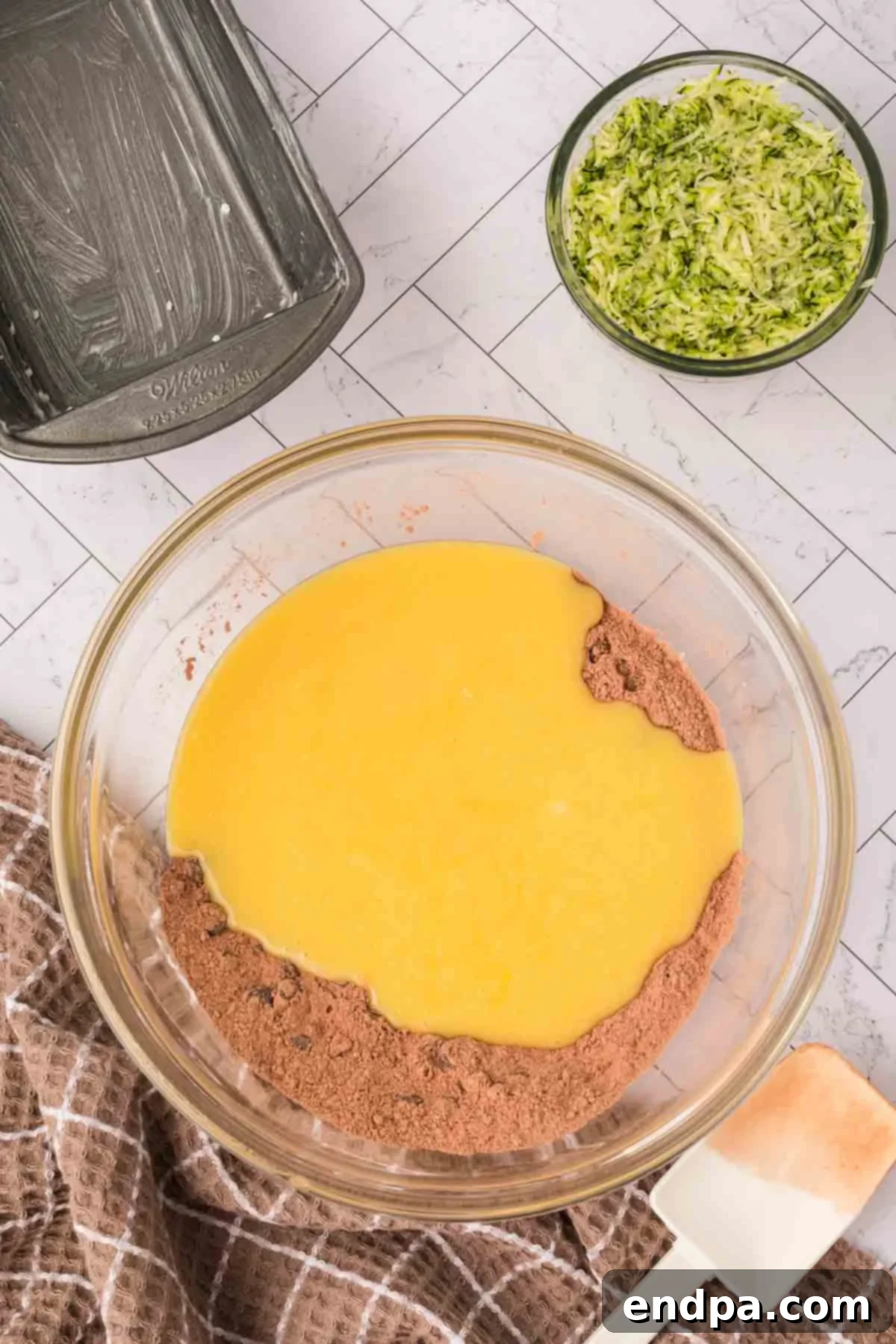 The wet ingredients being poured into the bowl of dry ingredients.