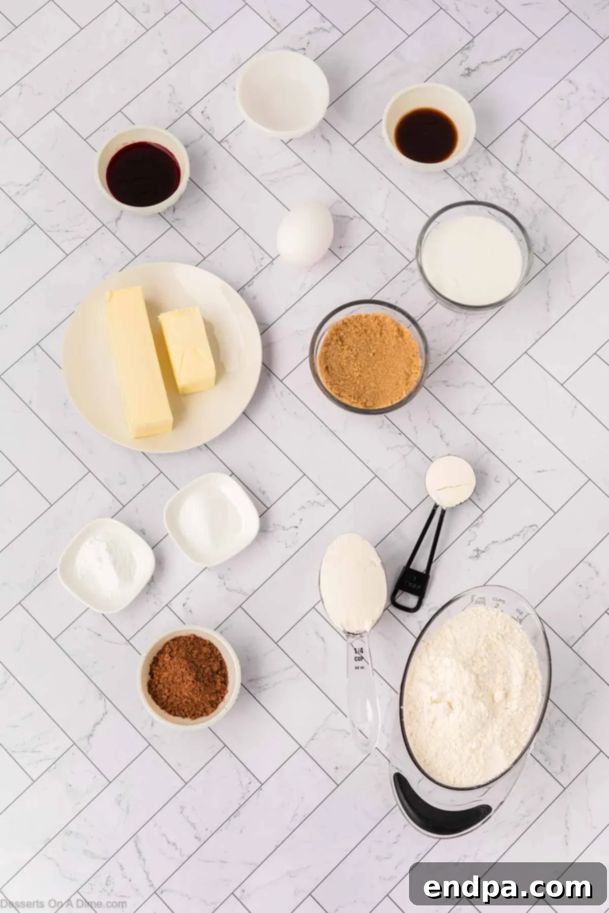 Ingredients for Red Velvet Cookies - flour, cocoa powder, baking soda, salt, butter, sugar, egg, vanilla, red food coloring, and vinegar, laid out on a surface.