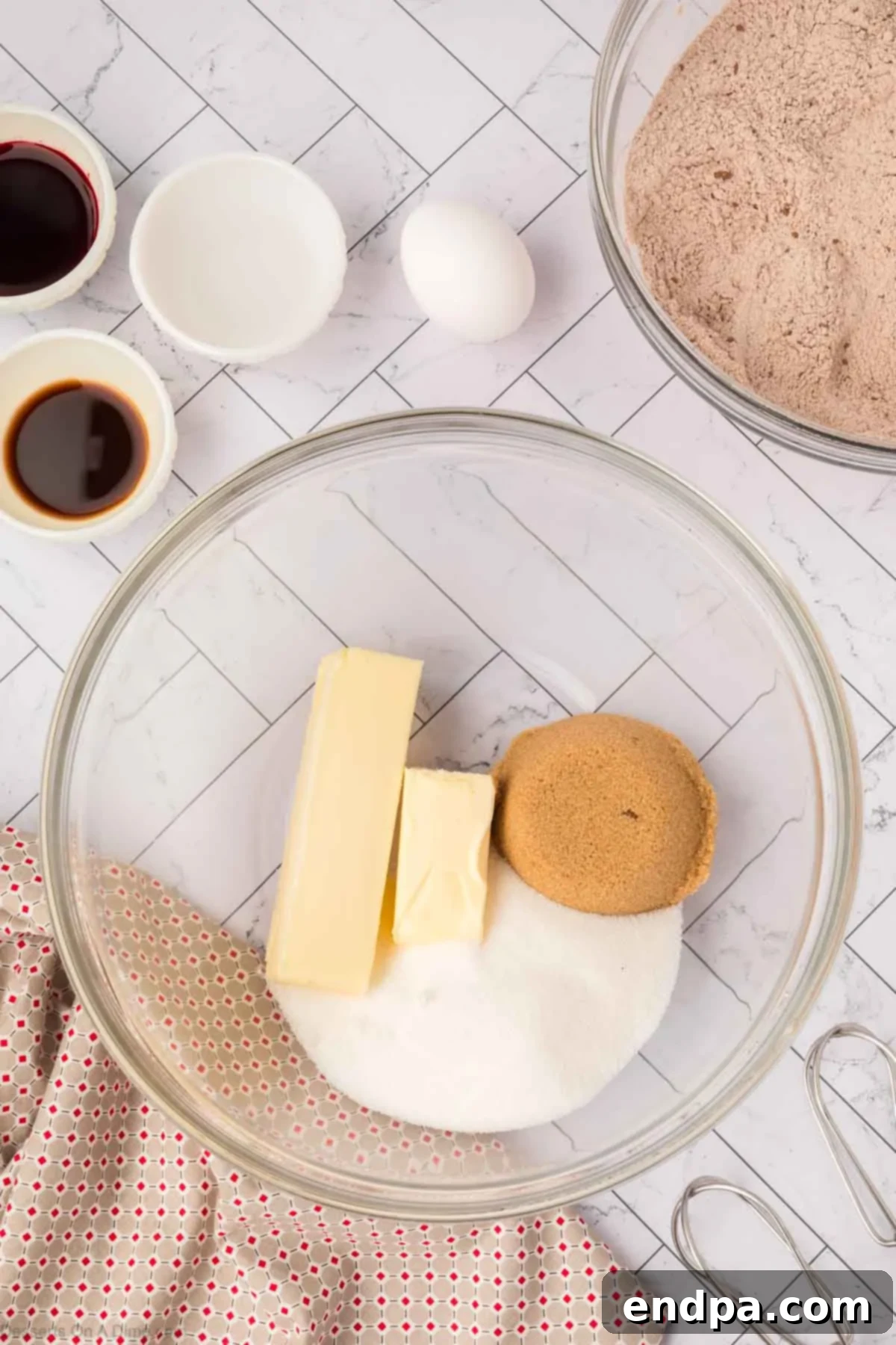 Softened butter and granulated and brown sugars in a mixing bowl, ready to be creamed.
