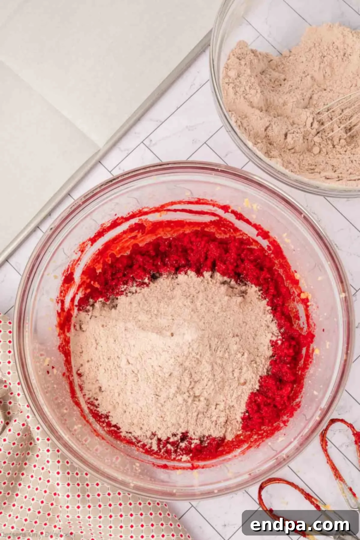 Dry ingredients slowly added to the wet mixture in a mixing bowl.