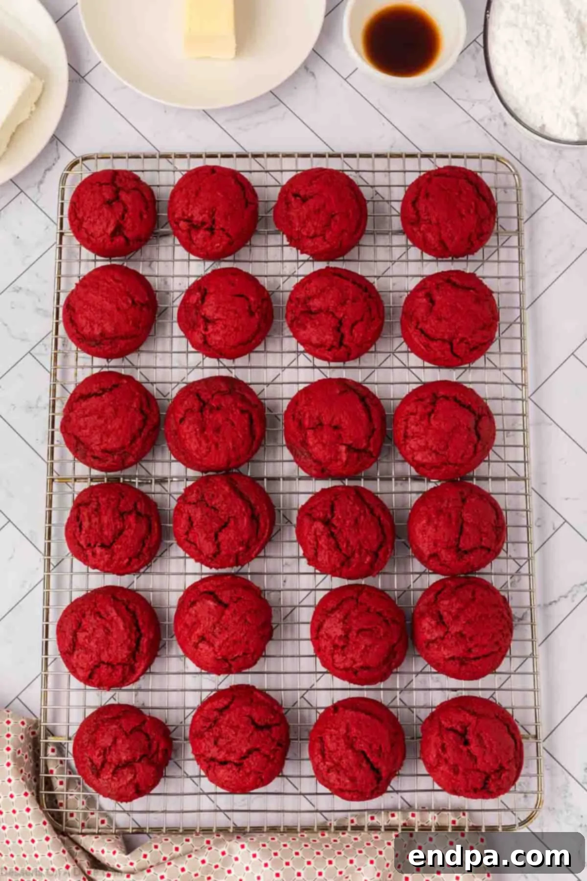 Baked red velvet cookies cooling on a wire rack.