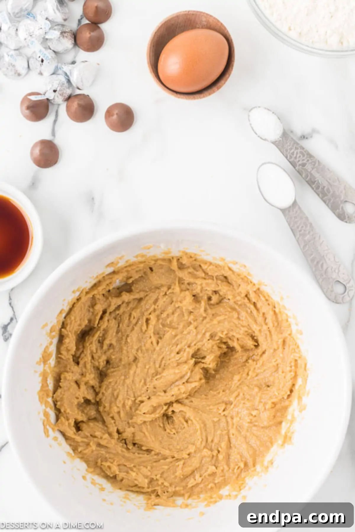 Combining creamy peanut butter, softened butter, granulated sugar, and brown sugar in a mixing bowl.