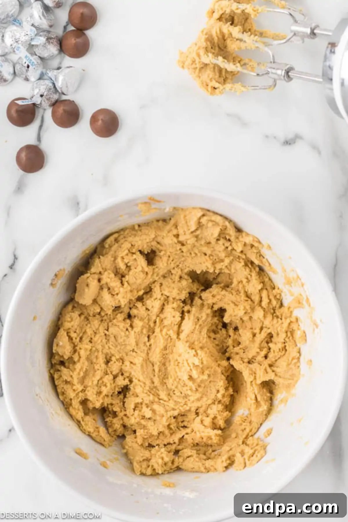 Slowly adding the whisked dry ingredients into the peanut butter mixture, beating until a soft dough forms.