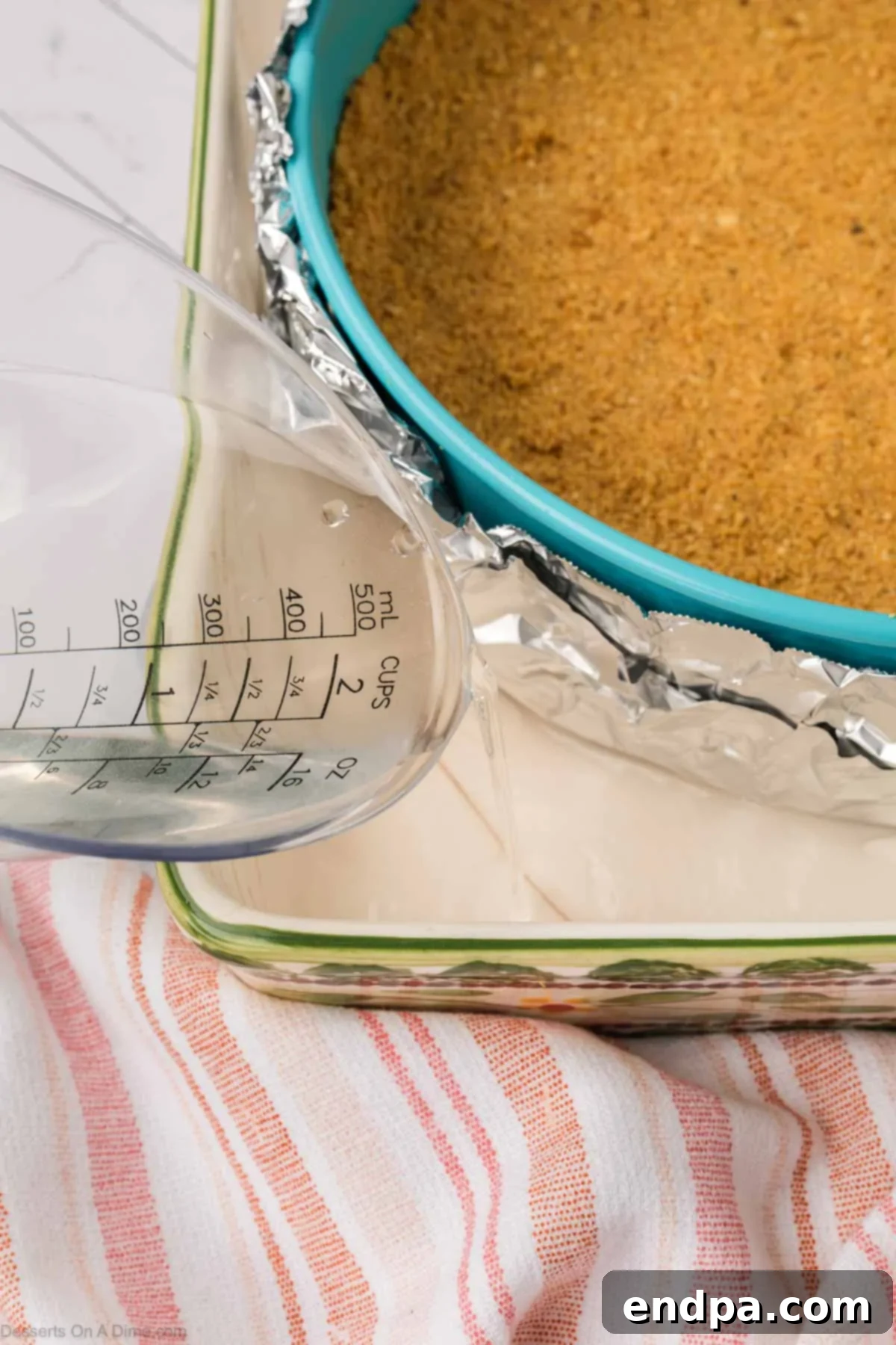 Velvet Sweet Potato Cheesecake 14 Hot water being carefully poured into the roasting pan around the cheesecake.