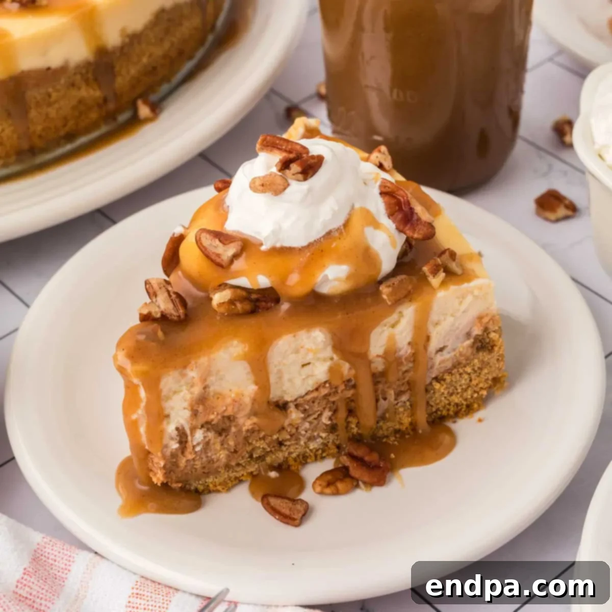 Velvet Sweet Potato Cheesecake 23 Slice of Sweet Potato cheesecake with caramel and pecans on a white plate.