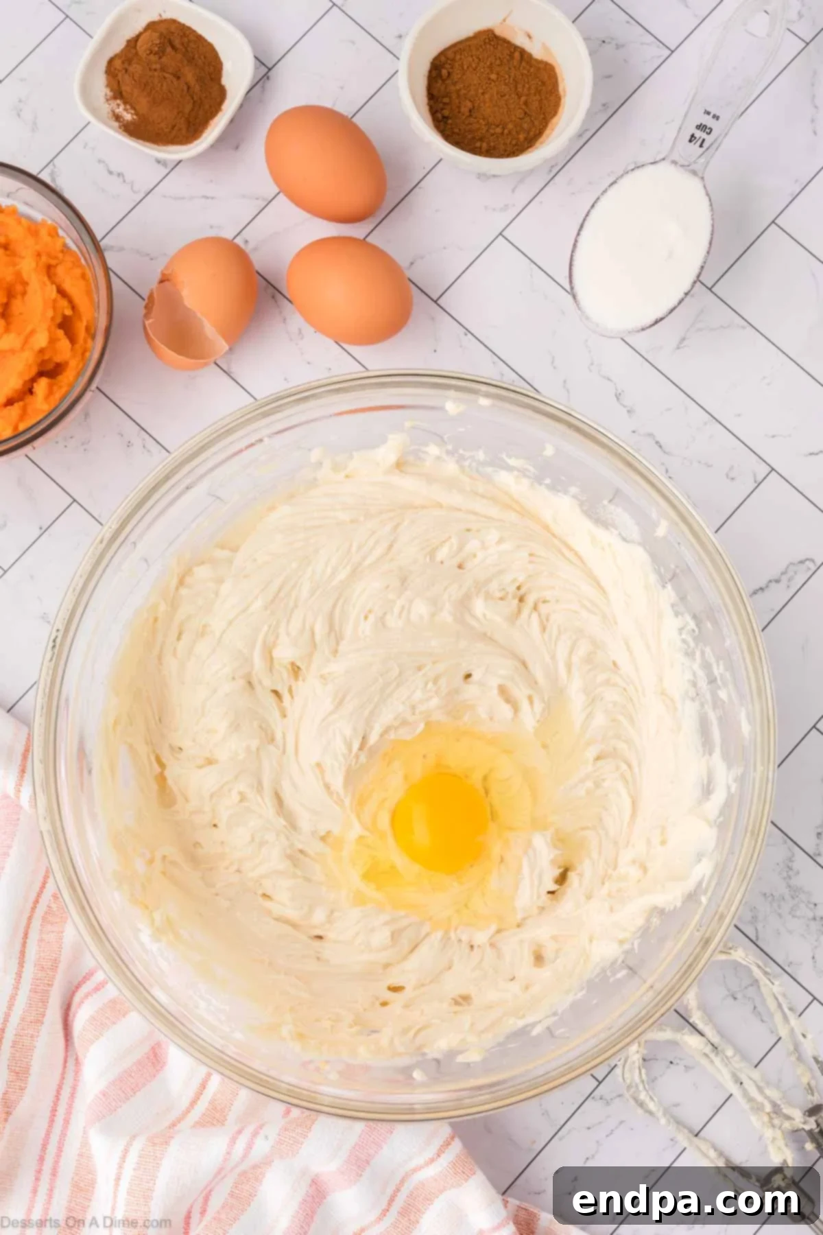 Velvet Sweet Potato Cheesecake 10 Eggs being added one by one into the cheesecake mixture.
