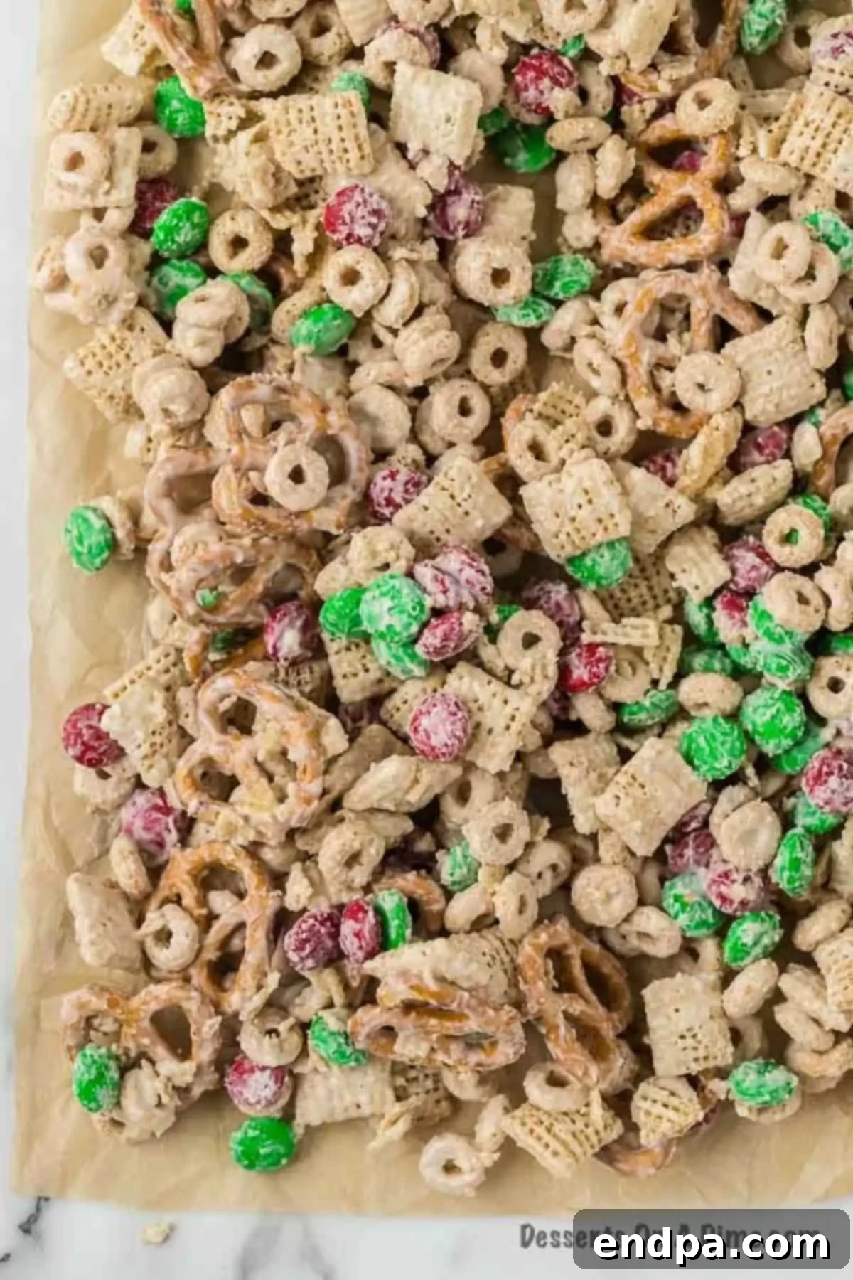 Irresistible Christmas Chex Mix 6 Cereal mixture coated in chocolate and spread on a baking sheet.