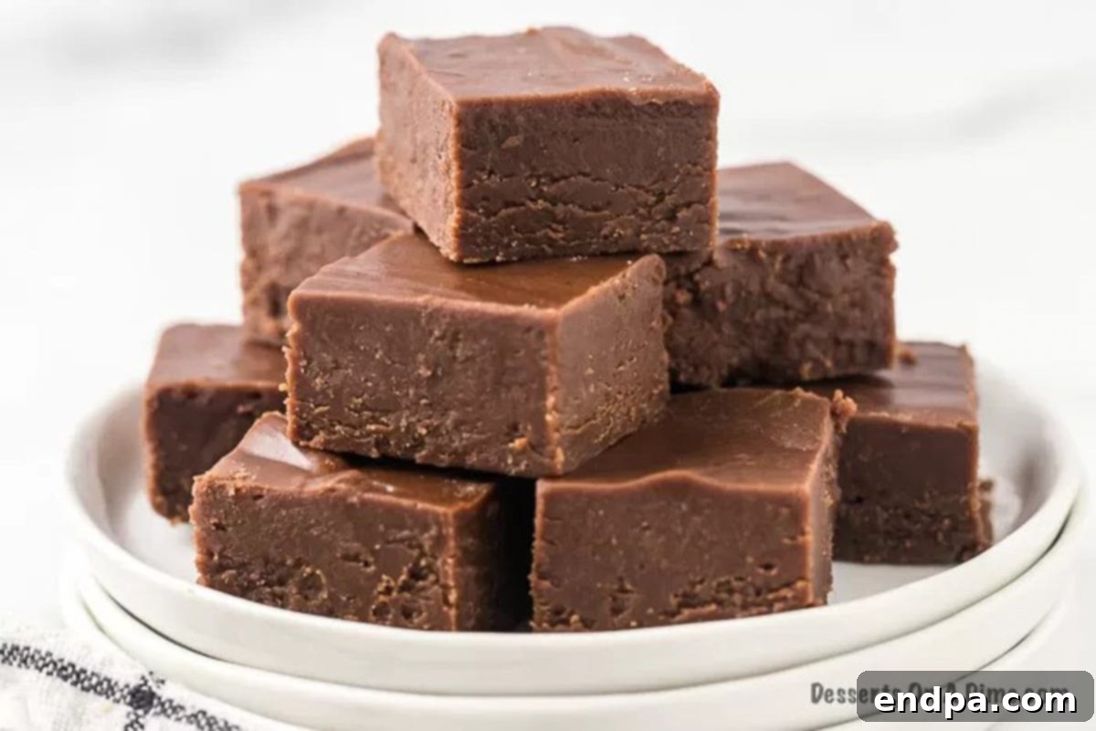 Perfectly cut squares of rich Chocolate Peanut Butter Fudge arranged on a elegant white platter, ready to be enjoyed.