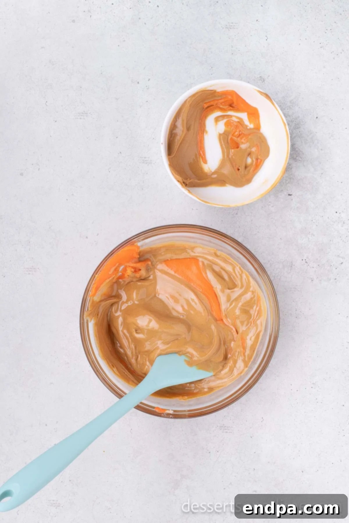 DIY Butterfinger Bliss 4 Microwave-safe bowl with melted candy corn and creamy peanut butter combined into a smooth mixture.