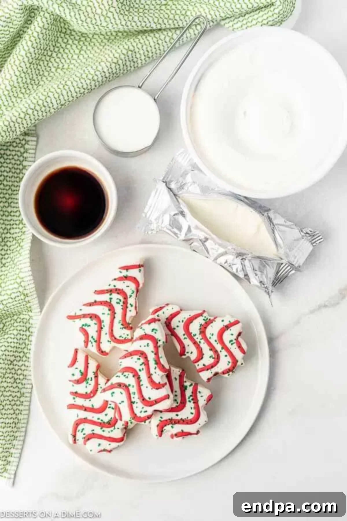 Ingredients for Christmas dirt cake including cool whip, cream cheese, milk, pudding, and Christmas tree cakes.