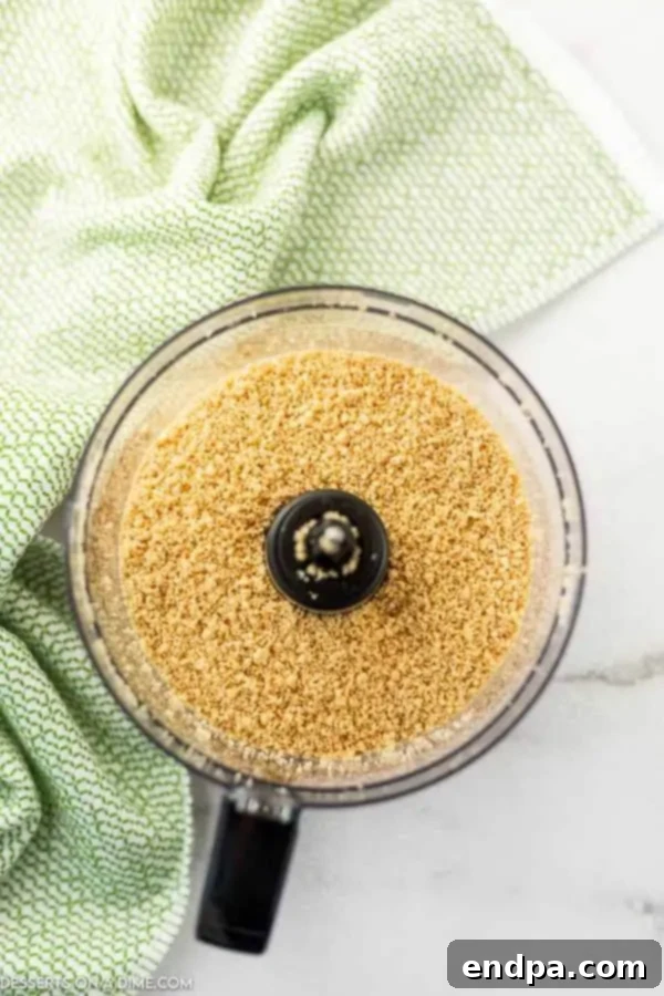 Crushed golden Oreo cookies in a food processor, ready for the dirt cake base.