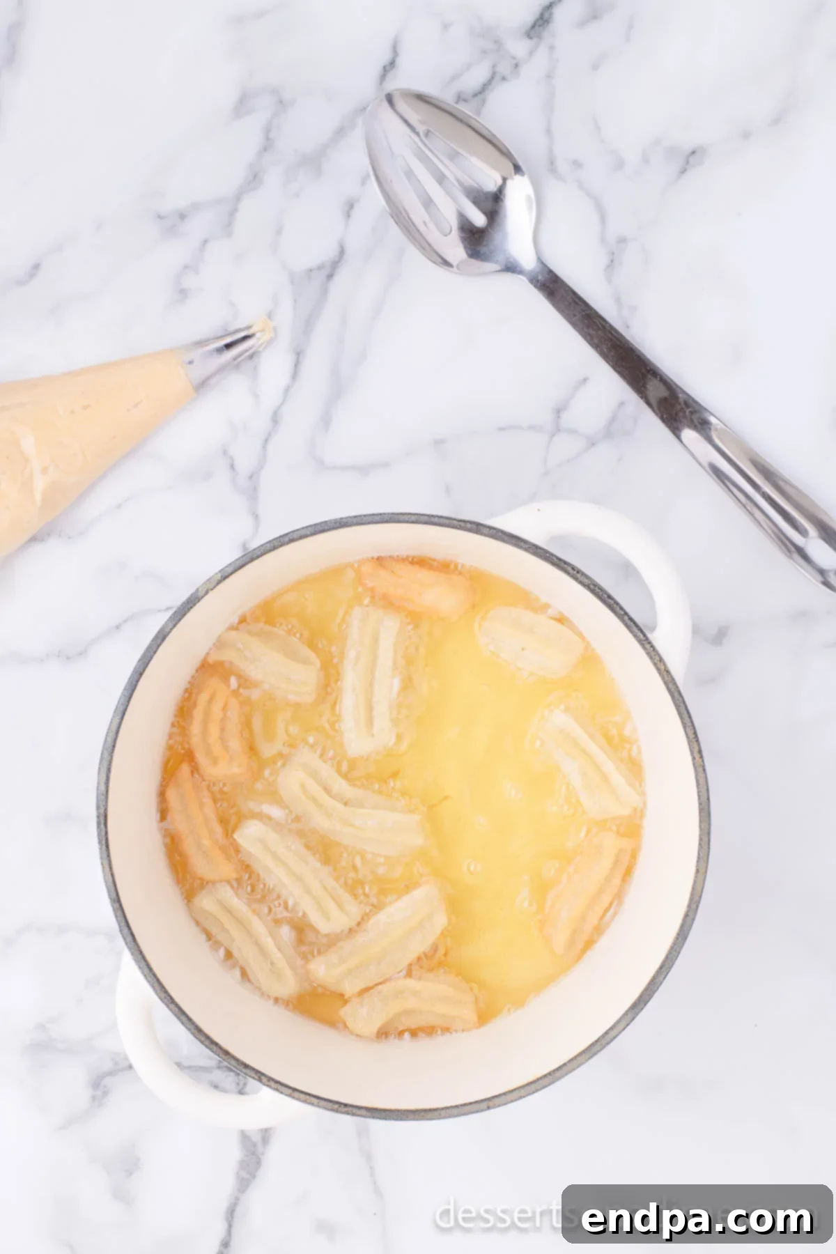 Churros in hot oil cooking. 