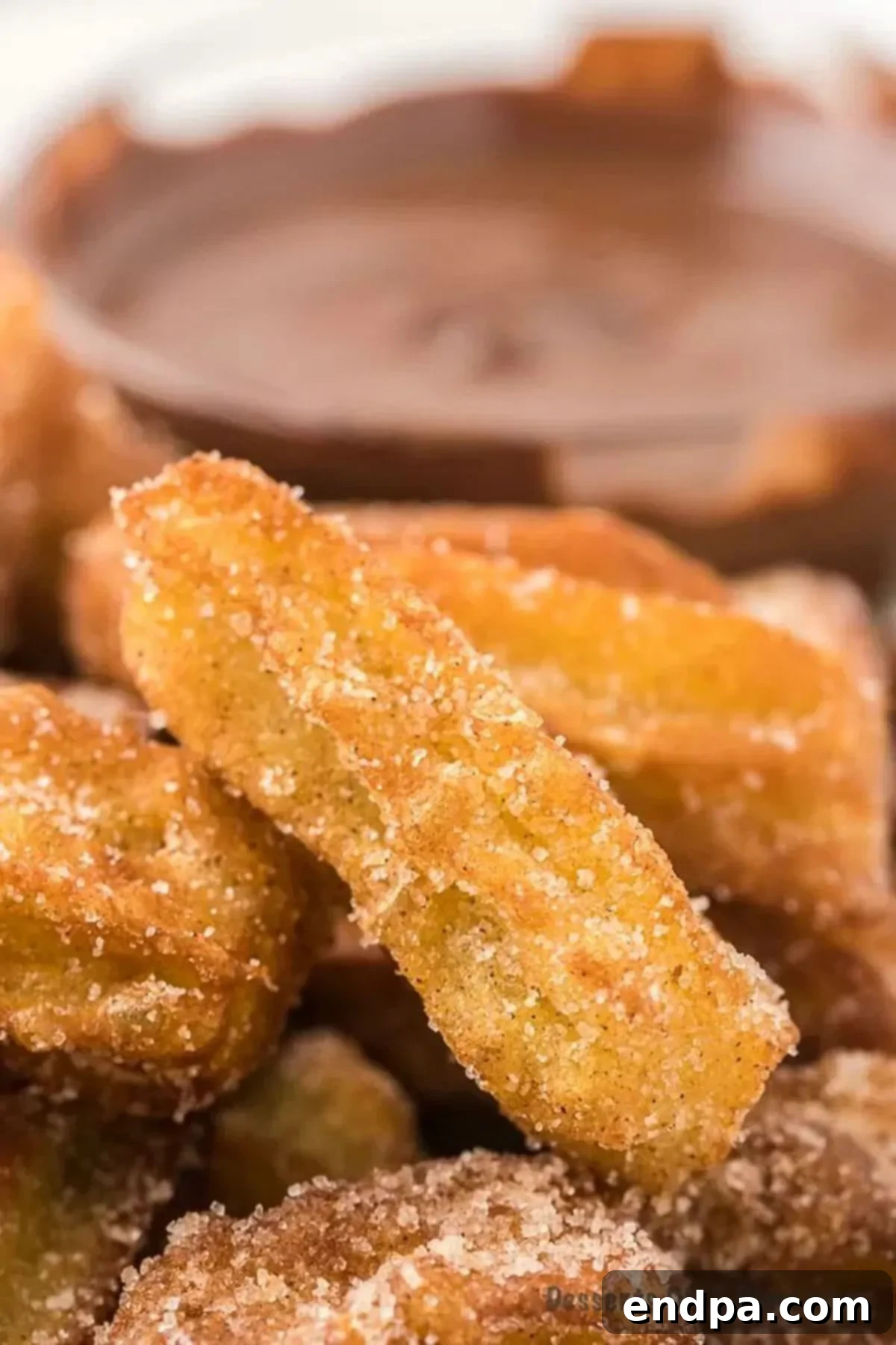 Churros on a platter beside chocolate sauce.
