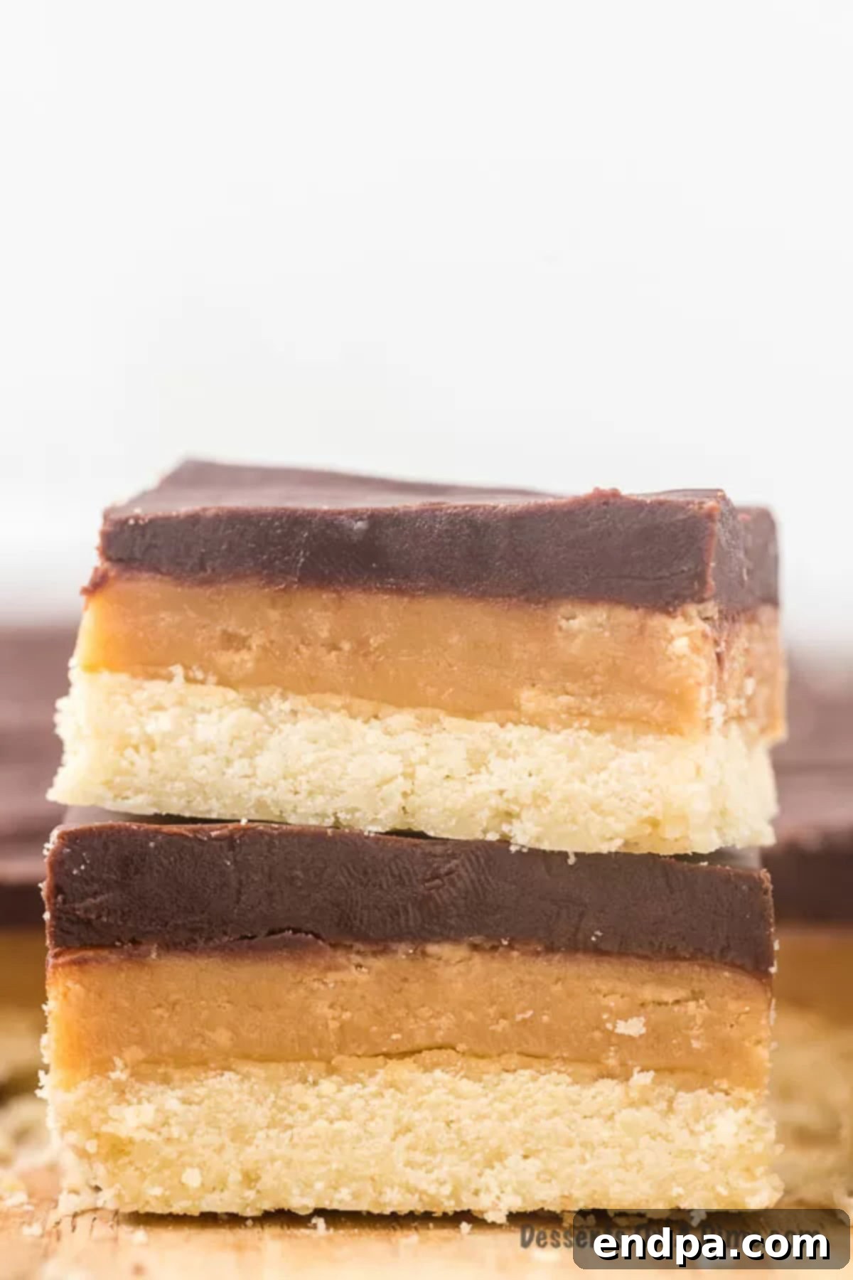 Make Your Own Twix Bars 2 Twix bars stacked on top of each other, showcasing the distinct layers of shortbread, caramel, and chocolate.