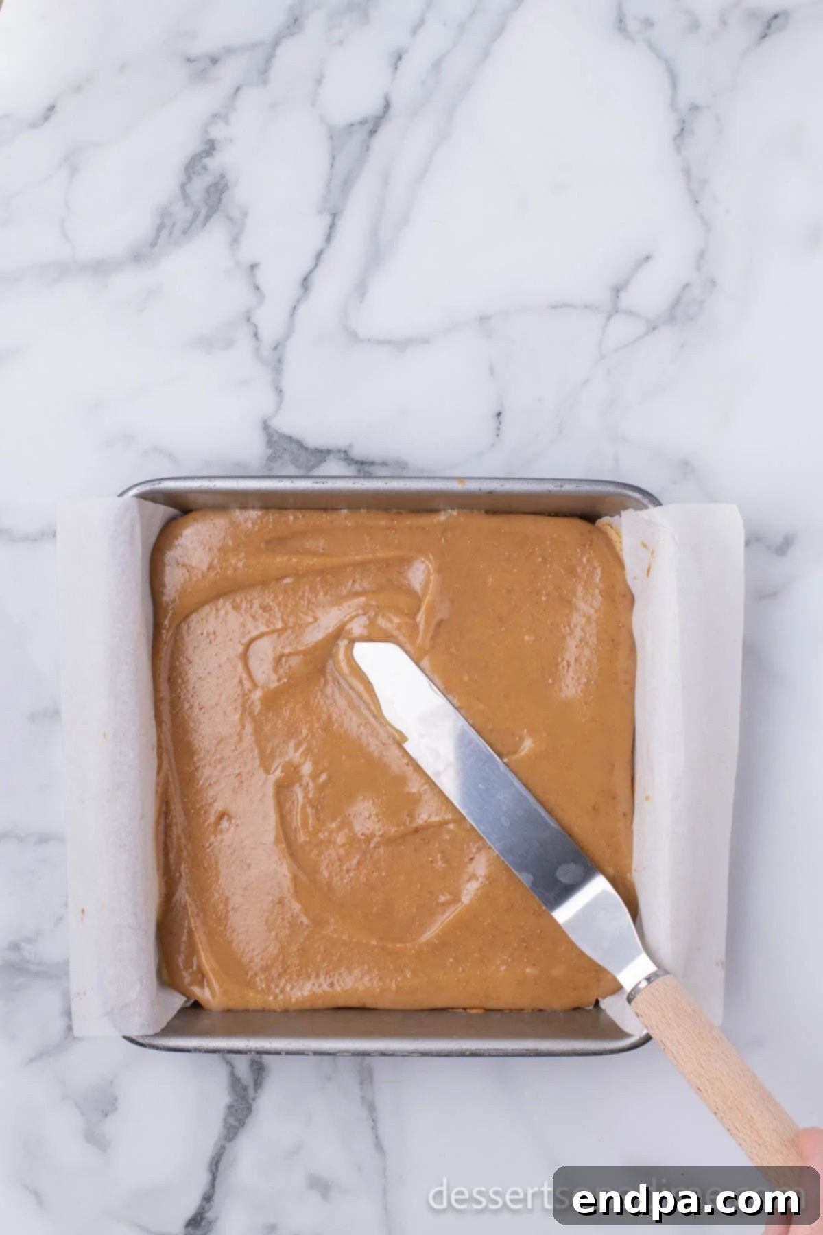 Make Your Own Twix Bars 12 Thickened caramel layer being poured and spread evenly over the cooled shortbread crust.