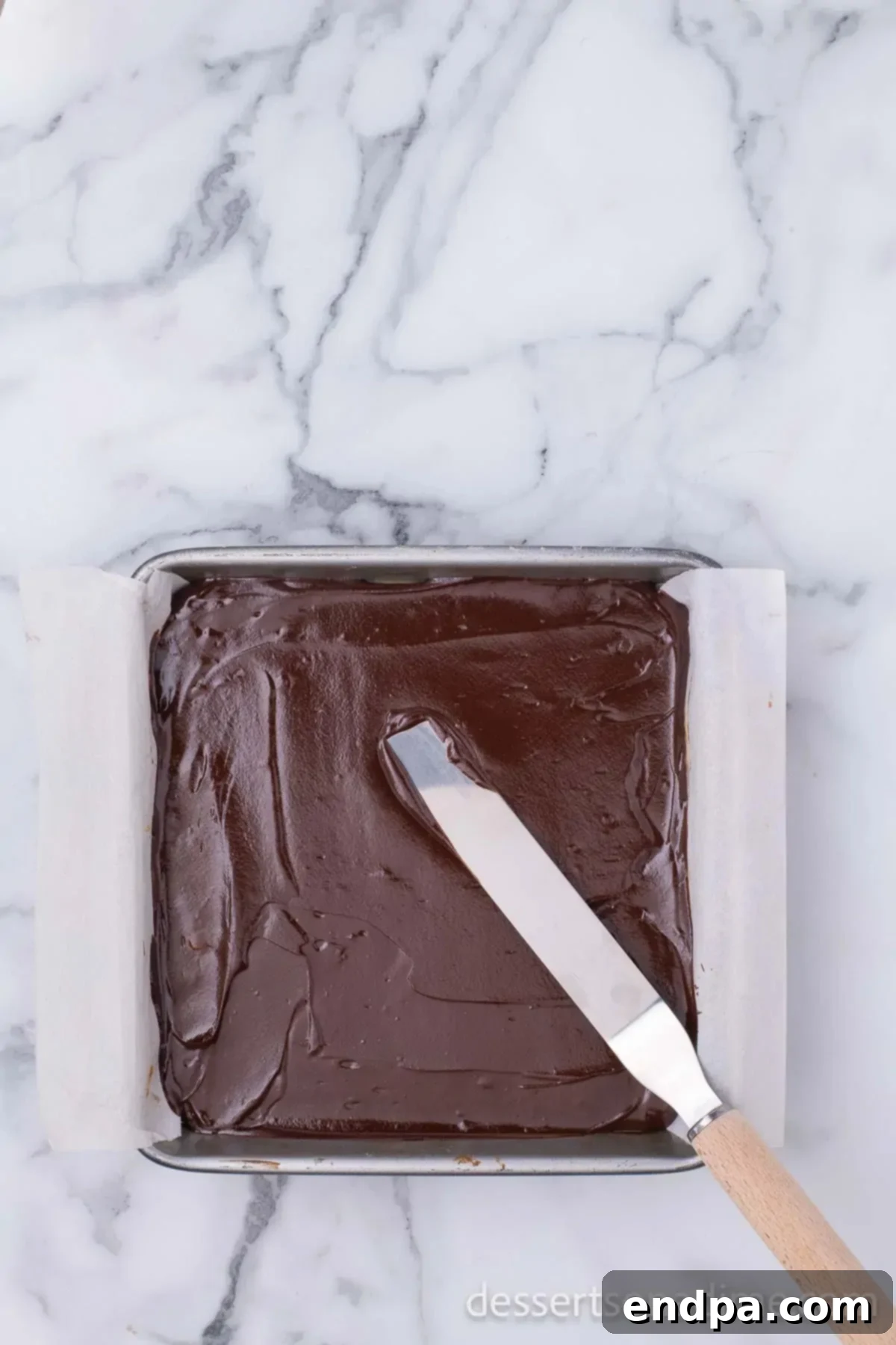 Make Your Own Twix Bars 14 The smooth, melted chocolate layer being spread evenly over the firm caramel layer.