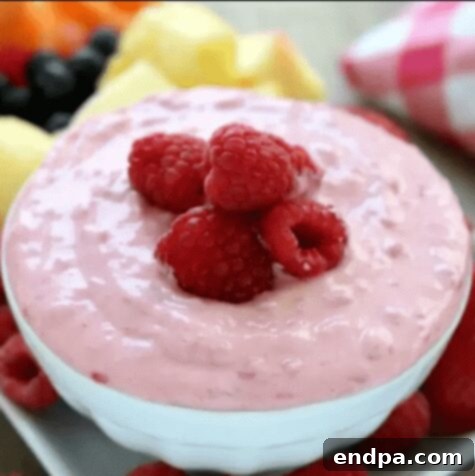 Blush Confections 7 Creamy Raspberry Fruit Dip served with fresh fruit, showcasing its vibrant pink color.