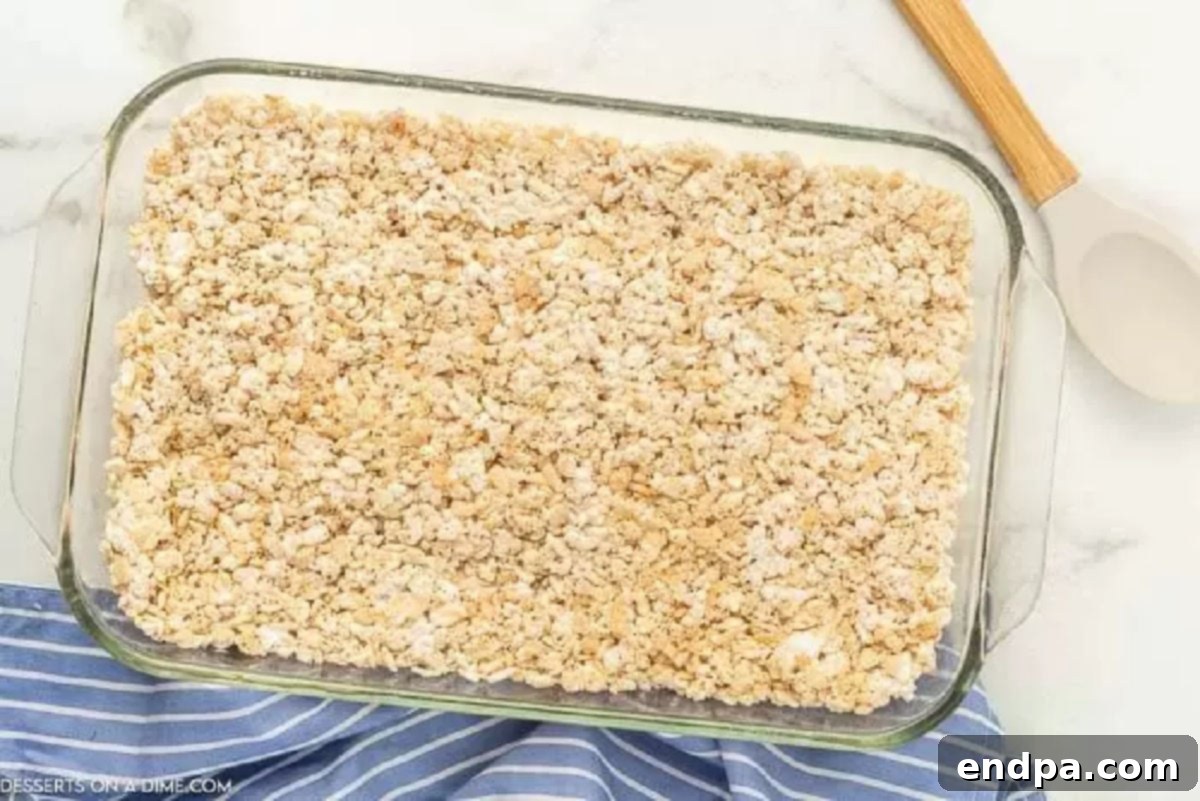 Cloud-Like Marshmallow Fluff Krispie Treats 5 The Rice Krispie and marshmallow fluff mixture spread evenly into a 9x13 inch baking dish.