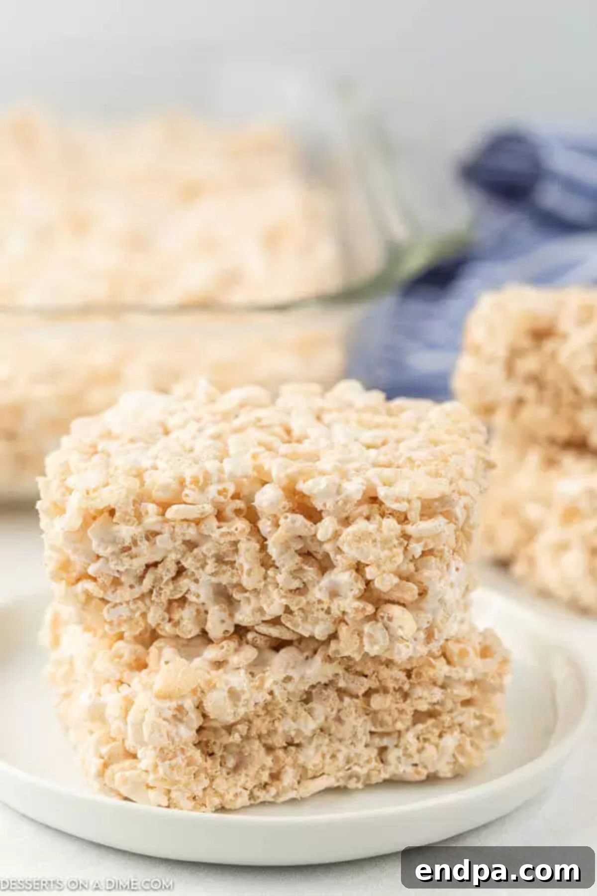Cloud-Like Marshmallow Fluff Krispie Treats 6 Individual Rice Krispie treat squares with marshmallow fluff, arranged on a plate for serving, highlighting their perfect golden brown and soft appearance.