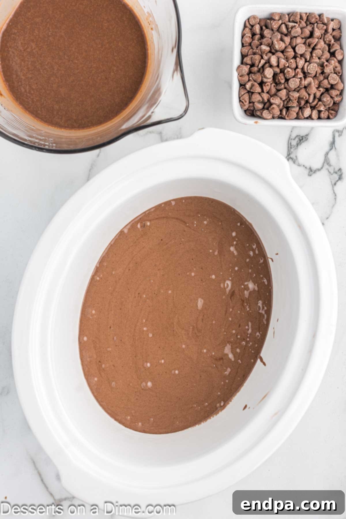 Effortless Slow Cooker Molten Chocolate Cake 5 Chocolate cake batter spread evenly in a crock pot.