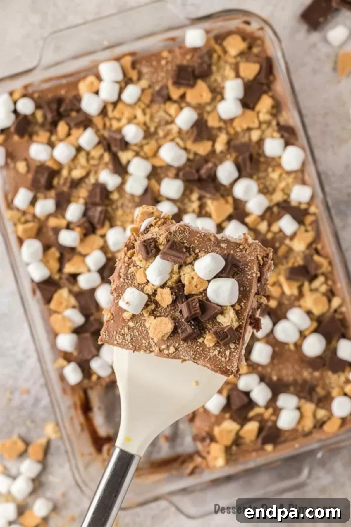 Campfire Delight Cake 13 A tantalizing overhead shot of a S'mores Poke Cake, topped generously with perfectly toasted marshmallows, chocolate pieces, and graham cracker crumbs.