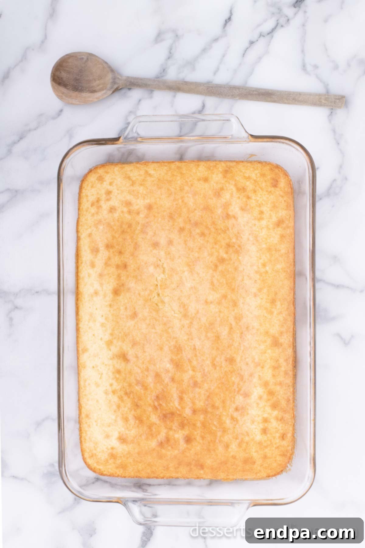 Campfire Delight Cake 3 A freshly baked cake in a baking pan, ready for the next steps of the S'mores Poke Cake recipe.