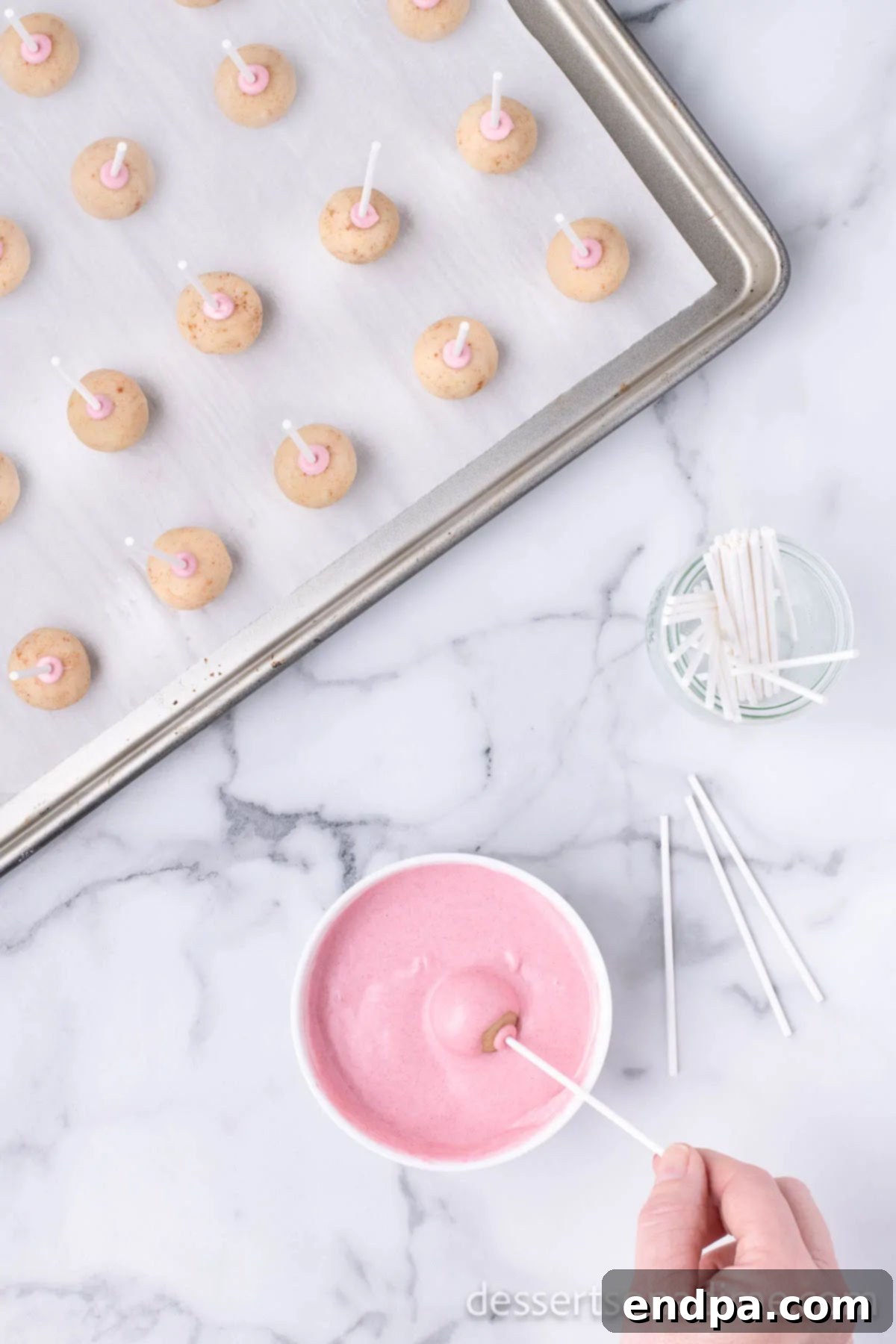 Copycat Starbucks Cake Pops 12 Cake pops coated in pink candy melts and placed in a stand to dry.