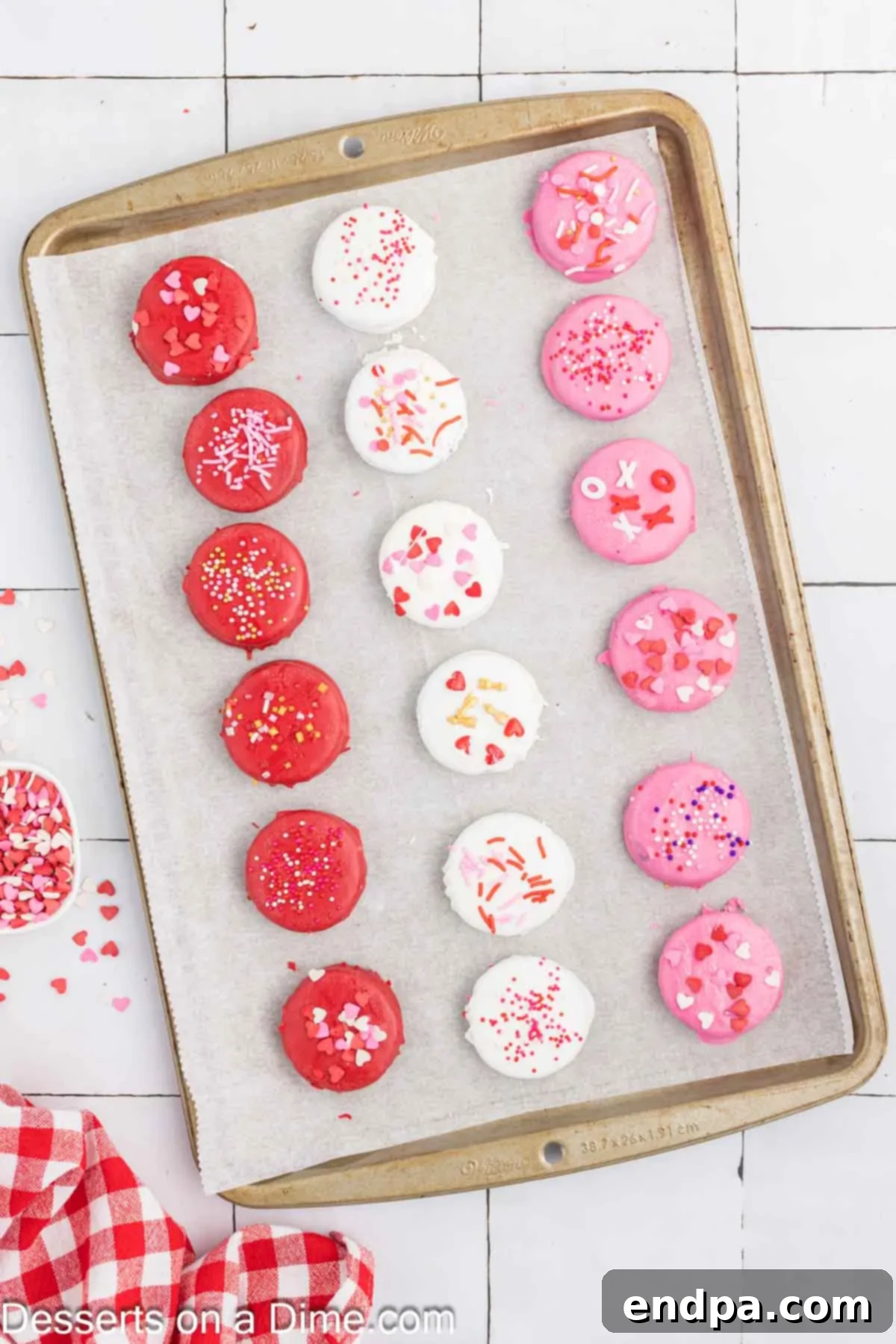 Love-Dipped Chocolate Oreos 6 Oreo cookies dipped in candy melts and topped with sprinkles on a baking sheet, ready to set.