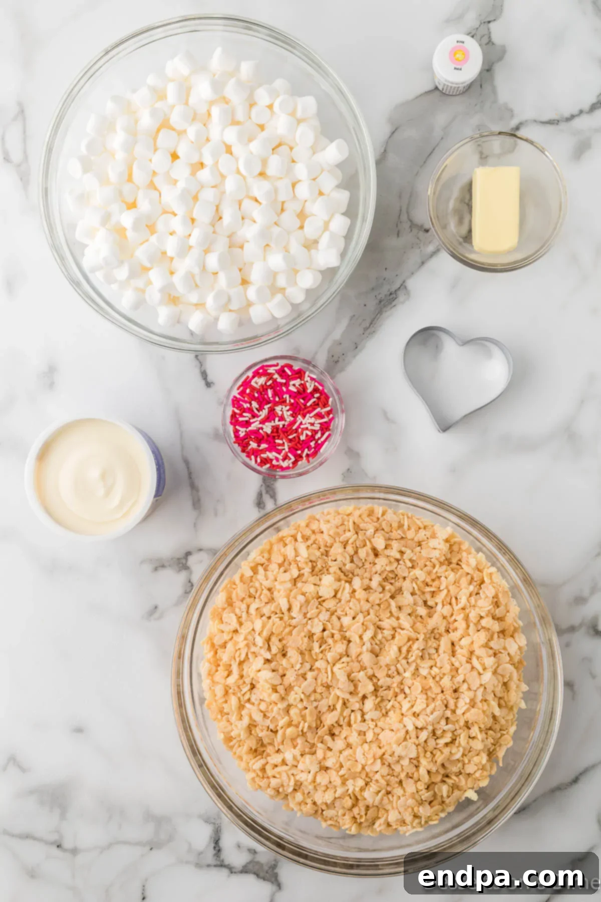 Sweetheart Crispy Treats 3 Ingredients for recipe - rice krispie cereal, mini marshmallows, red food coloring, frosting, sprinkles. A clear display of all components needed for Valentine Rice Krispie Treats.
