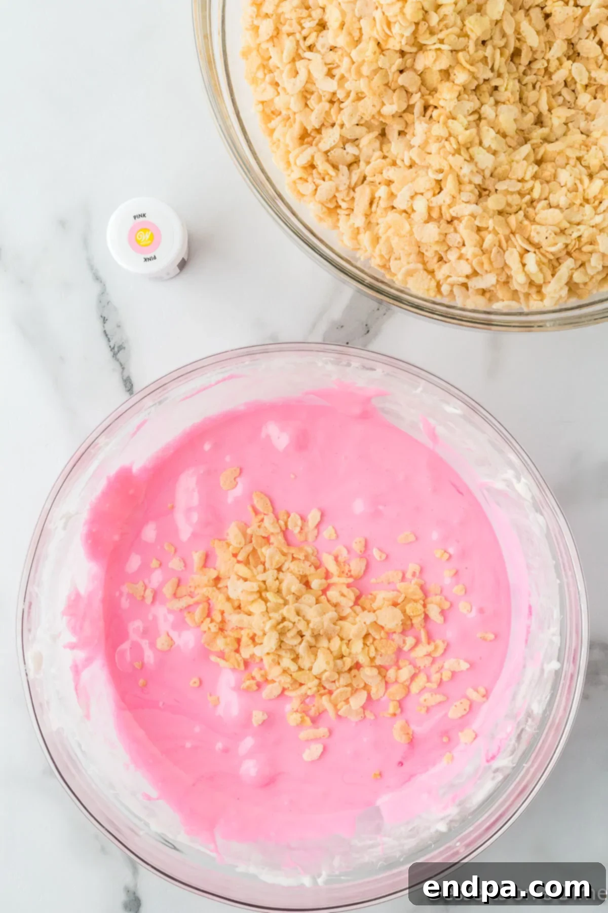 Sweetheart Crispy Treats 6 Cereal added to mixture. Rice Krispie cereal being folded into the pink marshmallow base.