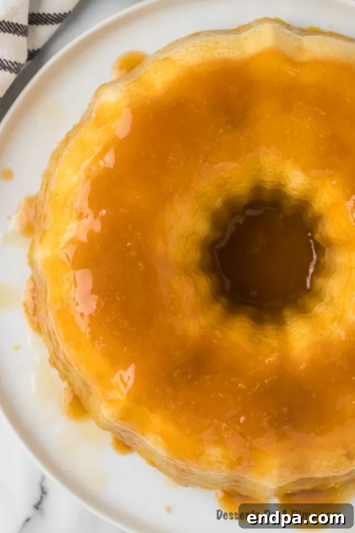 Beautiful Flan cake on a serving platter, showcasing its dual layers and glistening caramel.