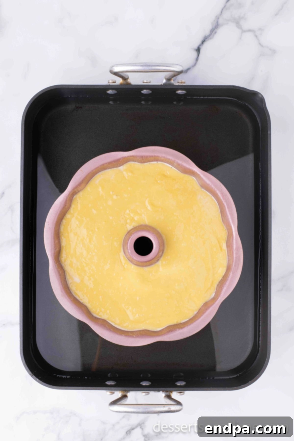 Bundt pan resting in a water bath inside the oven.