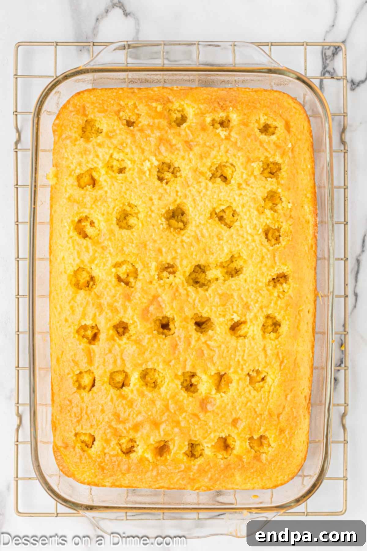 The lemon jello mixture being gently poured over the poked holes in the cake.
