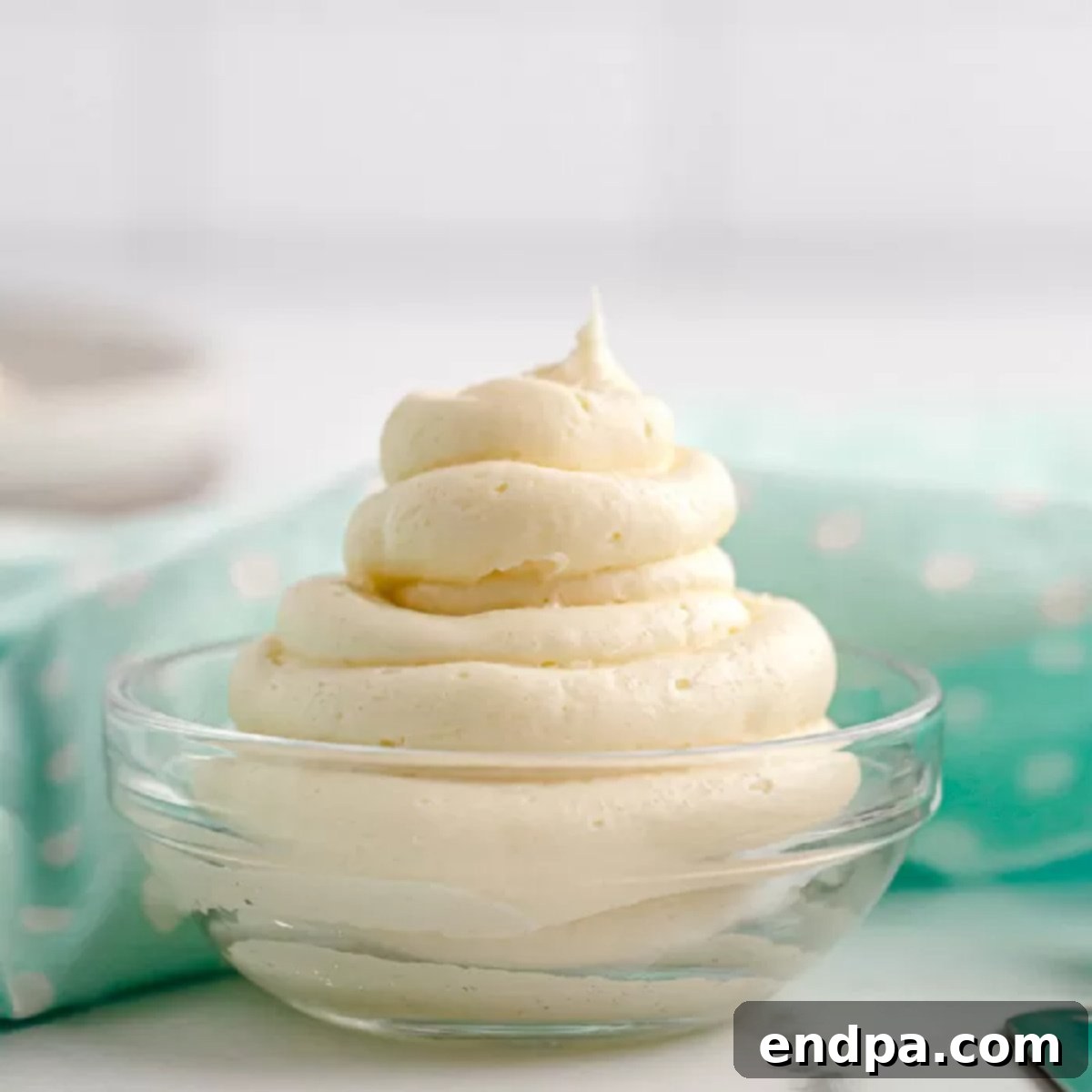 A bowl of whipped cream sits on a table.