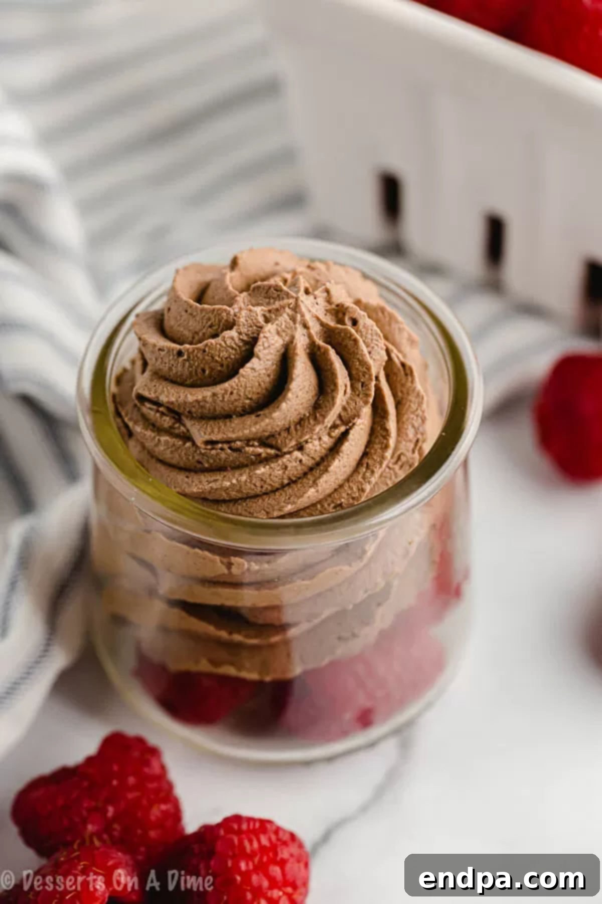 Keto Chocolate Mousse piped on top of fresh raspberries.