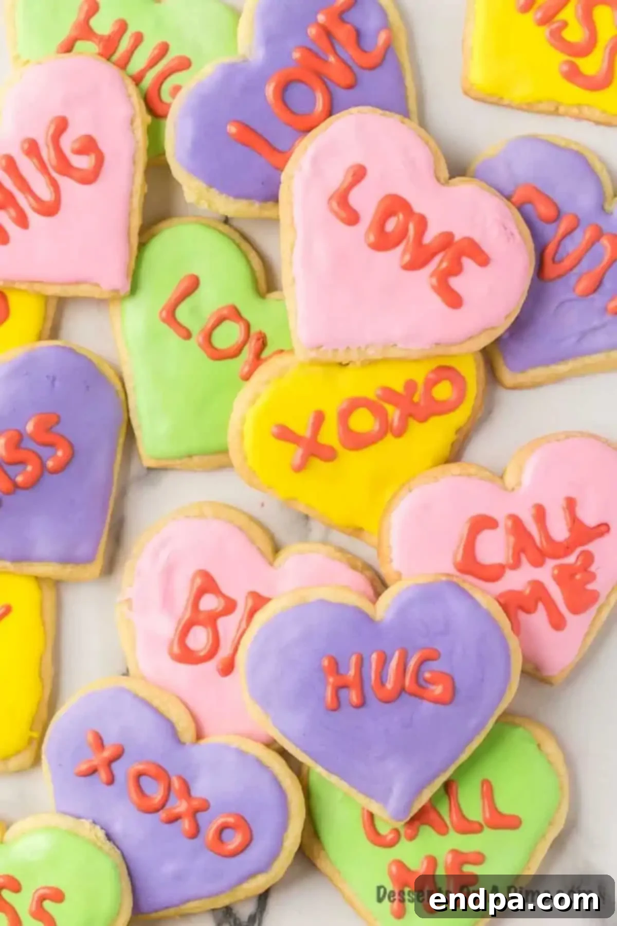 A vibrant spread of decorated Valentine's Day sugar cookies in various pastel colors.