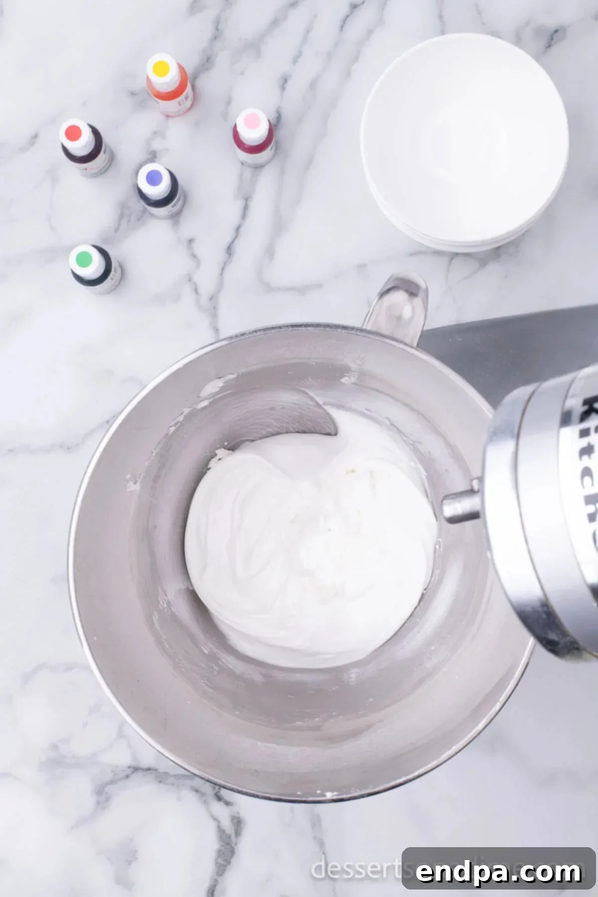 A mixing bowl filled with royal icing ingredients after being combined, showing a smooth, stiff consistency.