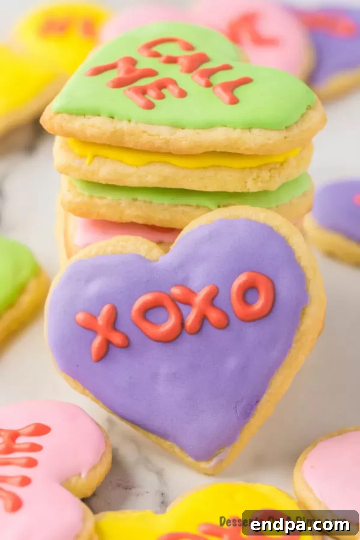 An array of beautifully decorated Valentine's Day sugar cookies, showcasing pastel colors and sweet messages, artfully arranged on a serving tray.