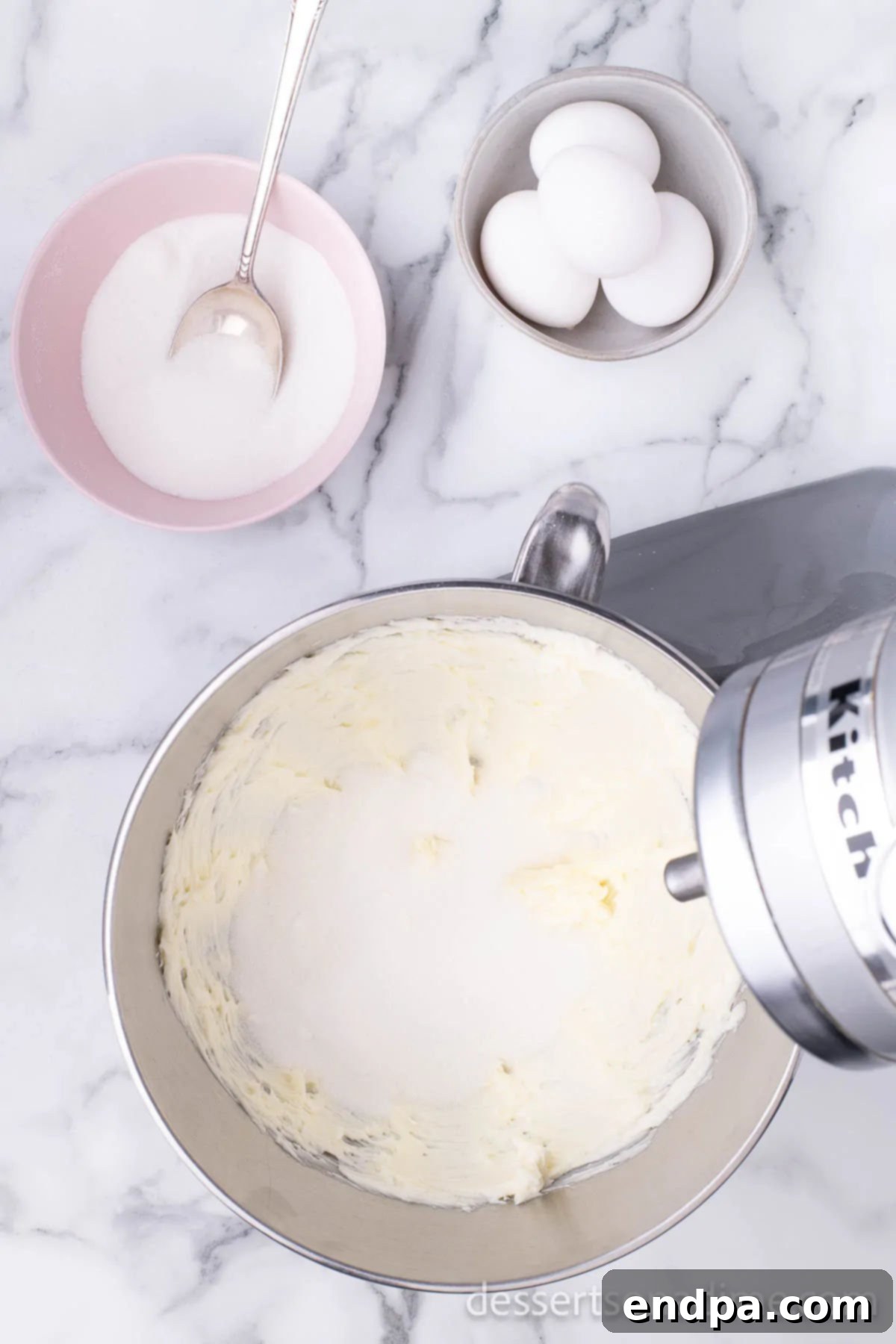 A mixing bowl containing softened butter and granulated sugar, ready for creaming.